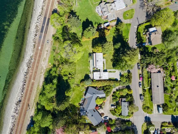an aerial view of residential house with outdoor space and trees all around