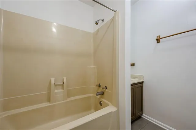a white bath tub sitting next to a white sink and vanity