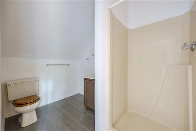 a bathroom with a granite countertop toilet and a sink