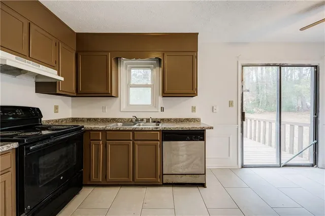 a kitchen with granite countertop a stove top oven microwave and cabinets