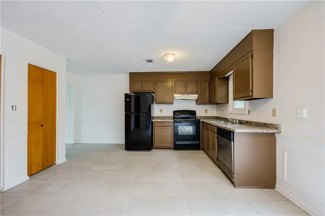 a kitchen with stainless steel appliances granite countertop a refrigerator stove and sink