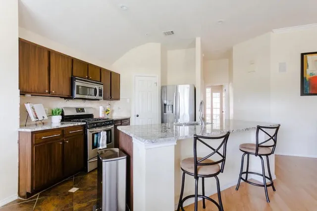 a kitchen with stainless steel appliances granite countertop a sink stove and refrigerator
