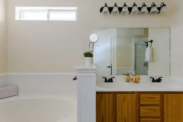 a bathroom with a tub sink and mirror