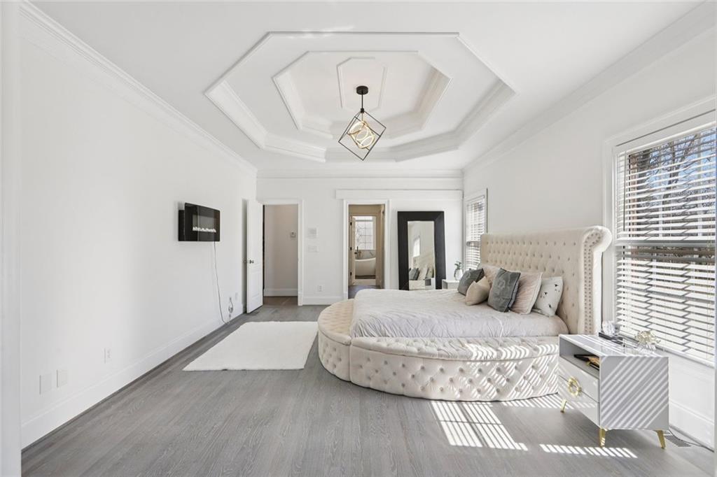 640 Ivy Lea Drive Southeast Lawrenceville, GA 30045 - Photo 24 of 79 a bedroom with a large bed and a chandelier
