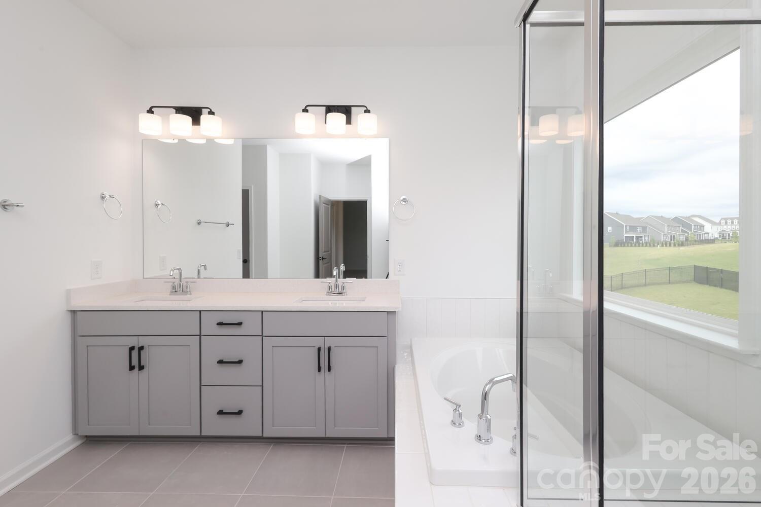 1190 Sugar Crk Road Fort Mill, SC 29707 - Photo 32 of 47 a bathroom with a double vanity sink a mirror and a bathtub