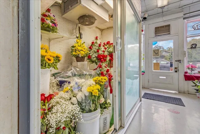 a room with lots of white furniture and a chandelier