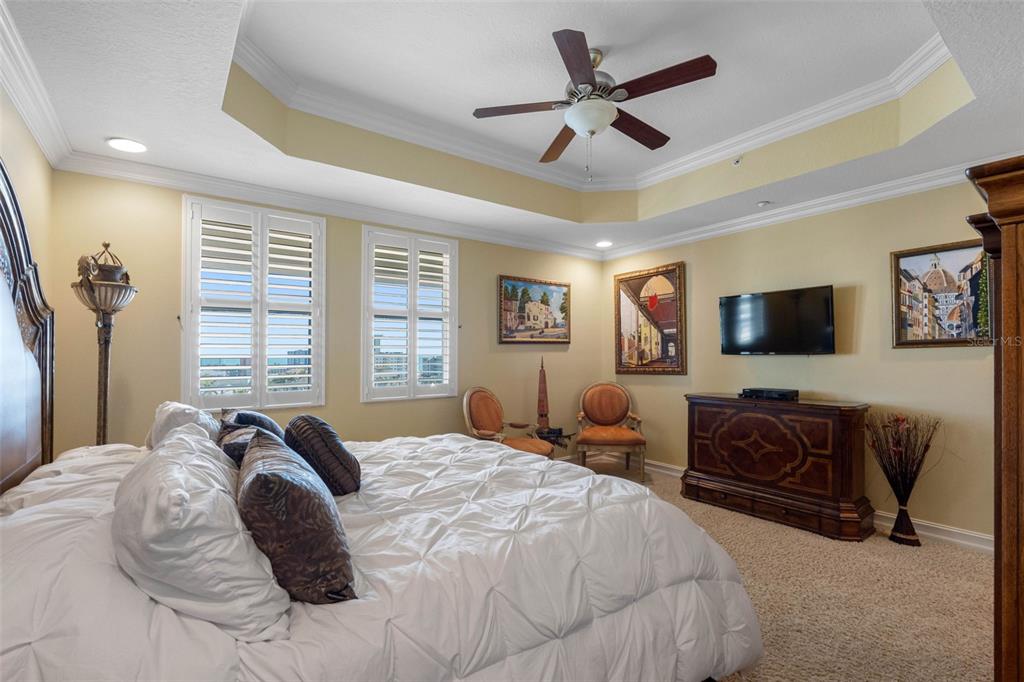 17717 Gulf Boulevard, Unit 702 Redington Shores, FL 33708 - Photo 68 of 99 a bedroom with a bed a couch and a flat screen tv