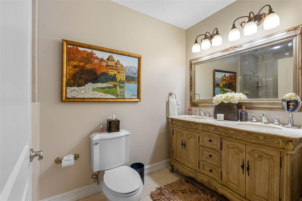 17717 Gulf Boulevard, Unit 702 Redington Shores, FL 33708 - Photo 69 of 99 a bathroom with a toilet a sink and mirror