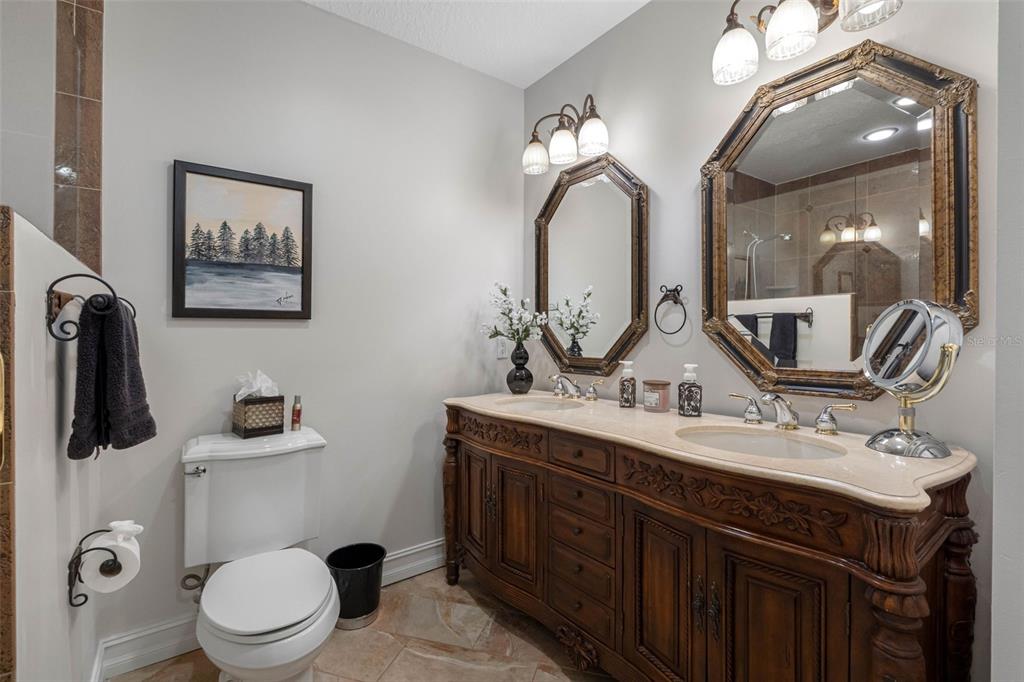 17717 Gulf Boulevard, Unit 702 Redington Shores, FL 33708 - Photo 76 of 99 a bathroom with a toilet a sink and mirror