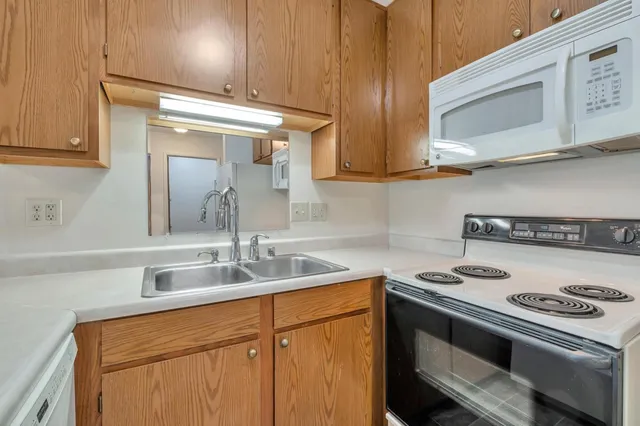 a kitchen with stainless steel appliances granite countertop a sink stove and microwave