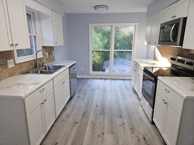 a kitchen with sink a stove and cabinets