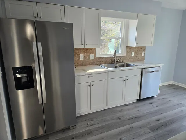 a kitchen with stainless steel appliances a refrigerator sink and cabinets