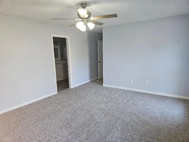 an empty room with a chandelier fan