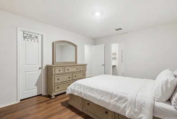 a spacious bedroom with a bed and a dresser