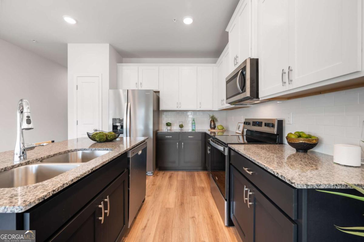 9435 Maple Grove Lane Jonesboro, GA 30238 - Photo 16 of 35 a kitchen with granite countertop lots of stainless steel appliances granite countertop a sink stove and refrigerator