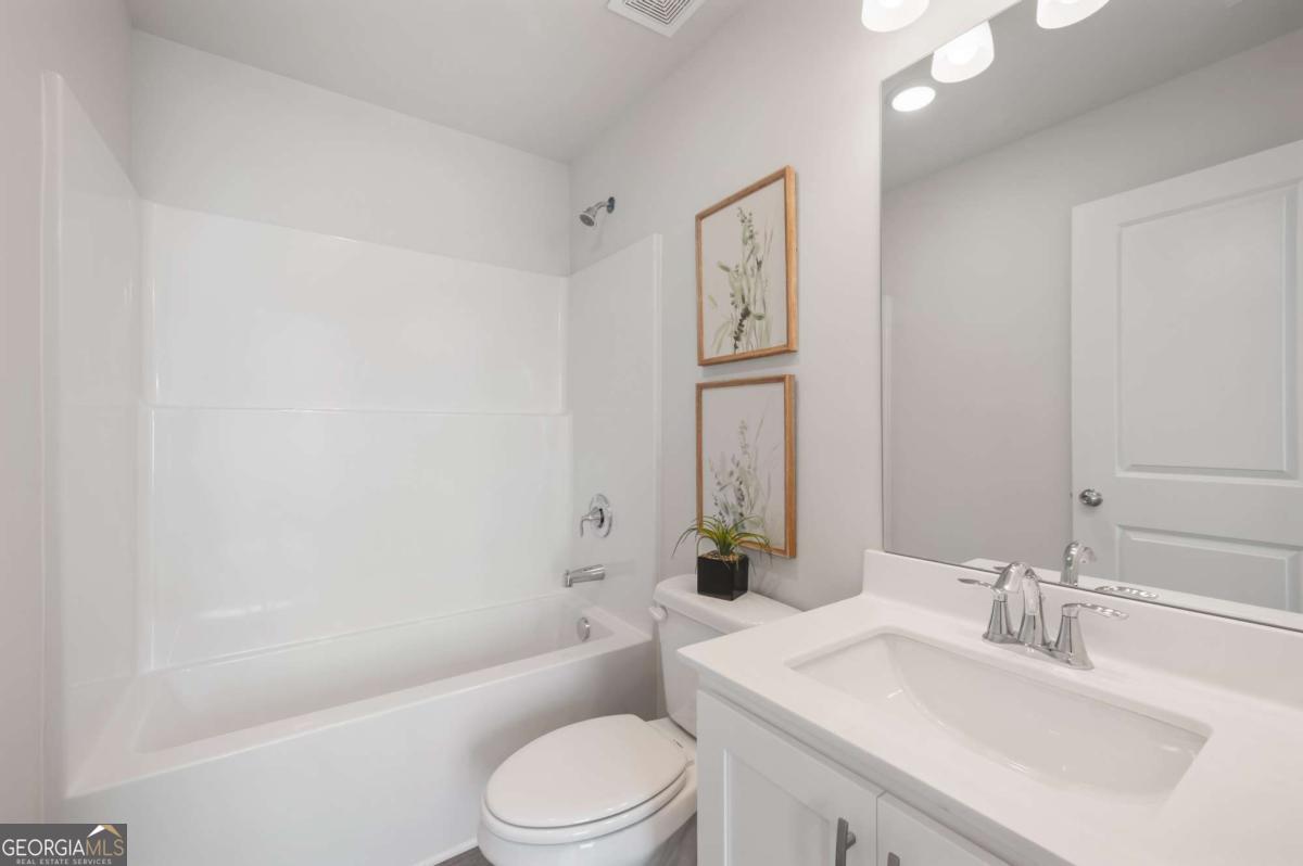 9435 Maple Grove Lane Jonesboro, GA 30238 - Photo 24 of 35 a bathroom with a granite countertop sink a toilet and shower