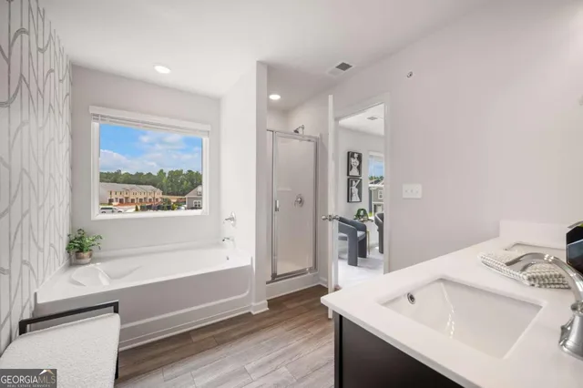 a bathroom with a sink a large mirror and a bathtub
