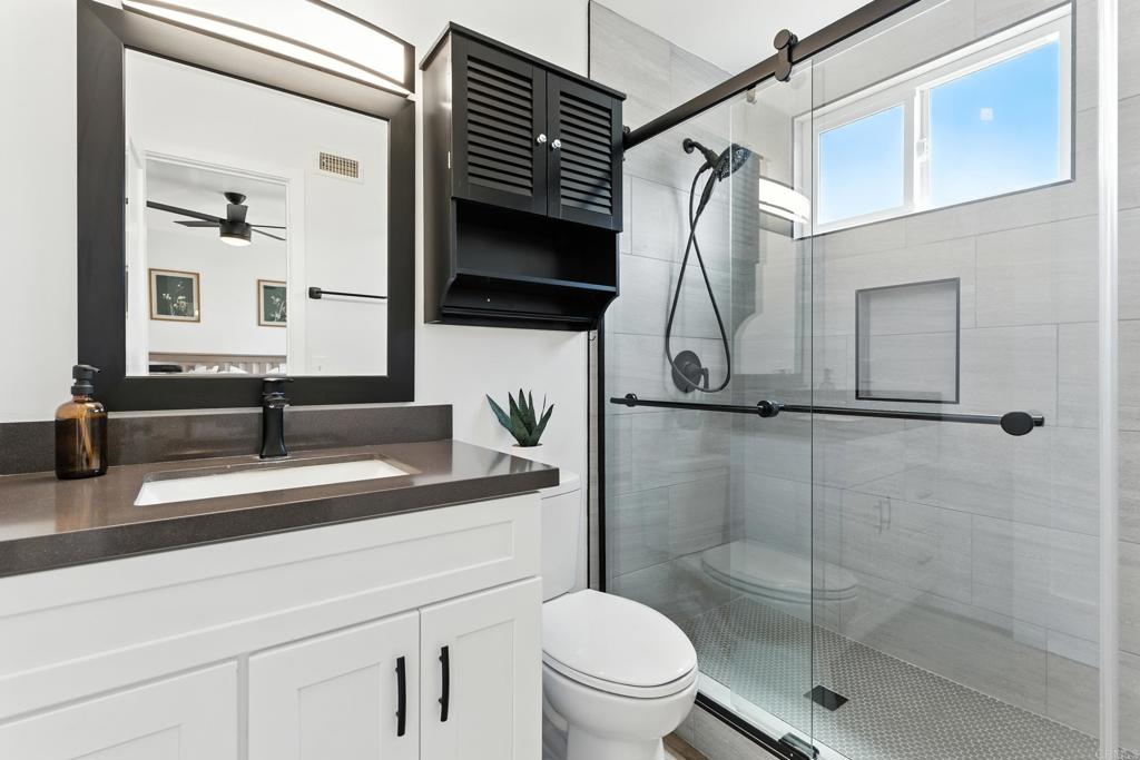 10021 Allenwood Way Santee, CA 92071 - Photo 14 of 28 a bathroom with a sink a toilet and shower