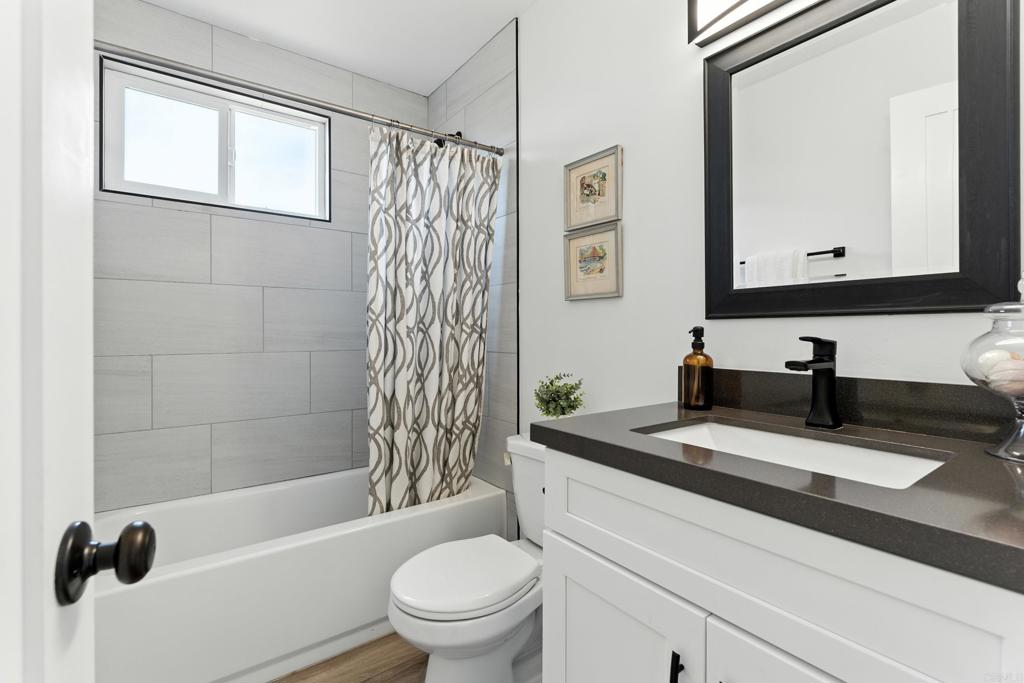 10021 Allenwood Way Santee, CA 92071 - Photo 19 of 28 a bathroom with a granite countertop sink toilet mirror and shower
