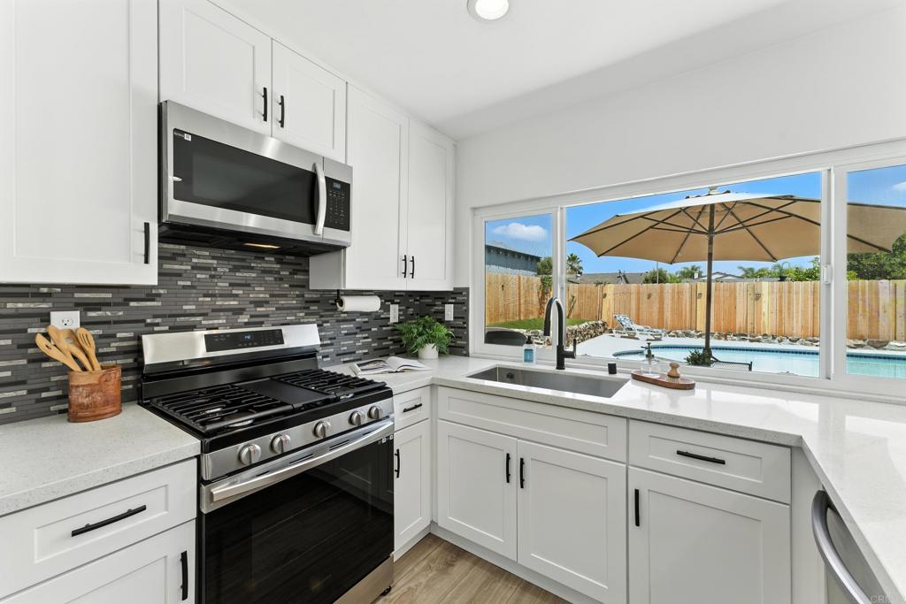 10021 Allenwood Way Santee, CA 92071 - Photo 9 of 28 a kitchen with stainless steel appliances granite countertop a sink a stove and a microwave
