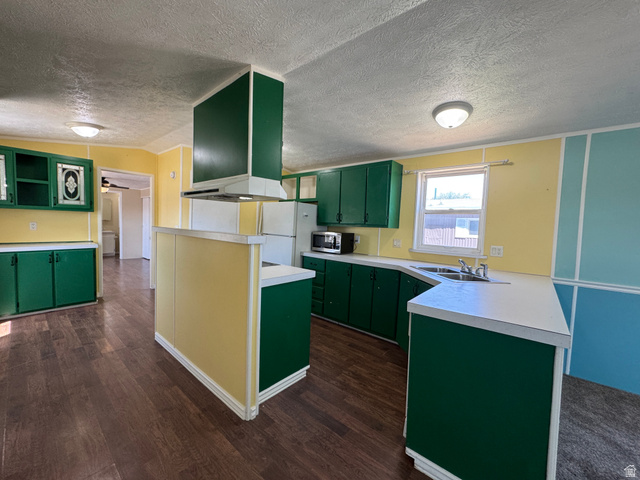 2491 Highway 89, Unit 315 Pleasant View, UT 84404 - Photo 22 of 34 Kitchen featuring wood-finish flooring, green cabinetry, white countertops, and a built-in range hood