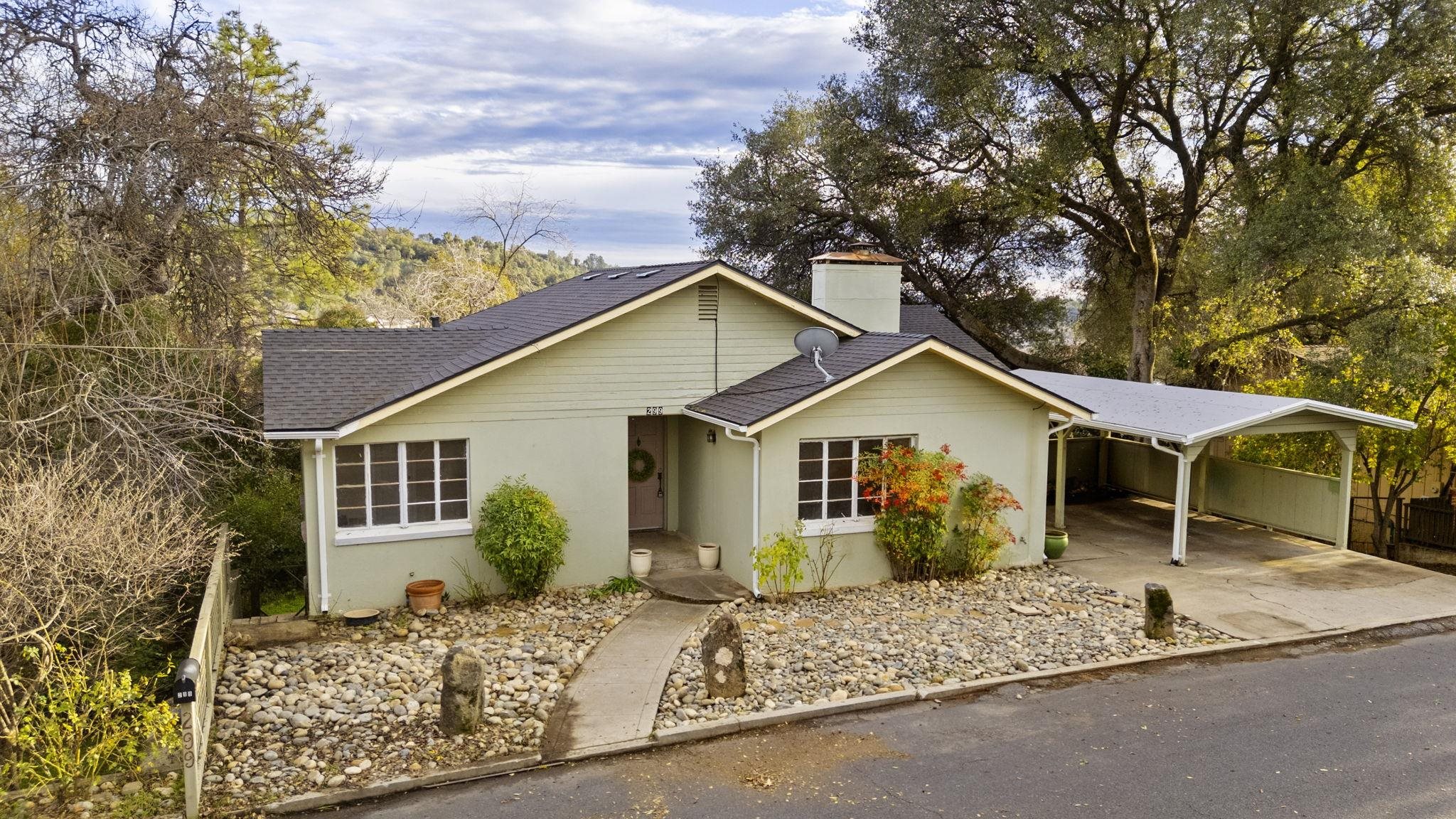 a view of a house with a yard and large tree