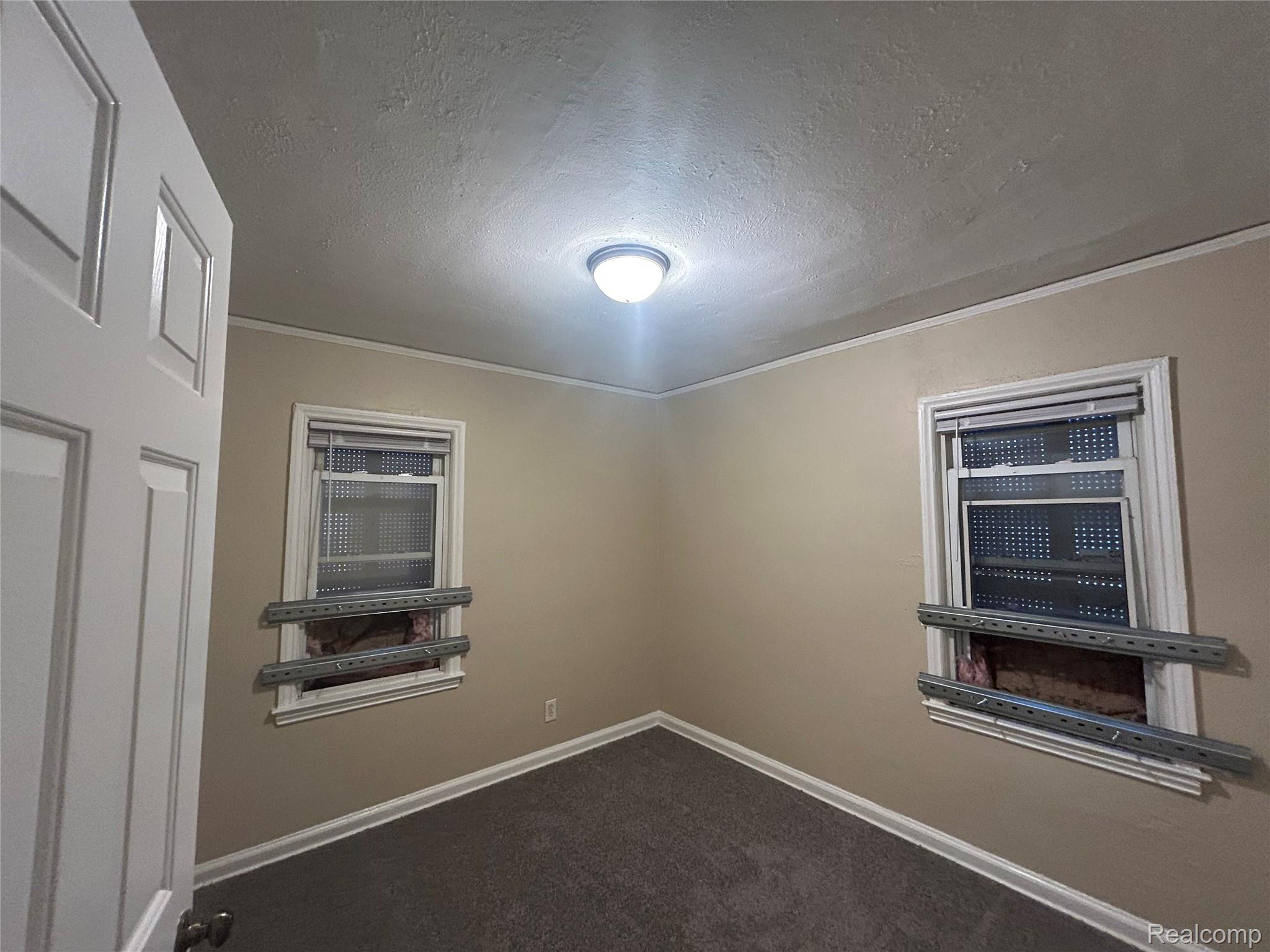 16824 Rutherford Street Detroit, MI 48235 - Photo 11 of 25 Neutral-toned walls complement the dark gray carpet flooring