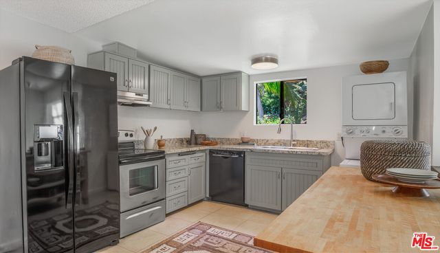a kitchen with stainless steel appliances granite countertop a refrigerator sink and stove
