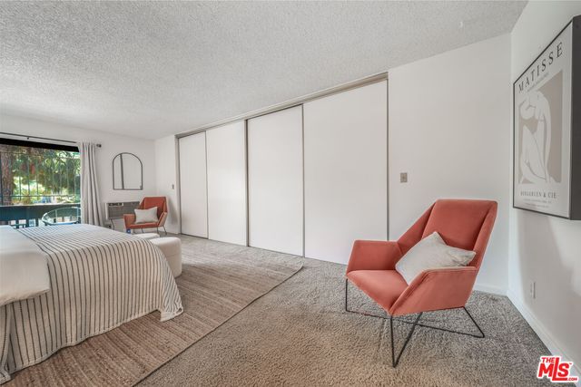 a bedroom with furniture and a flat screen tv