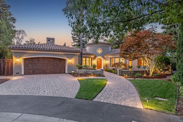 a front view of a house with a yard and potted plants