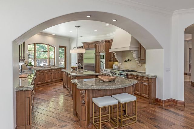 a view of a kitchen with granite countertop a table and chairs in it