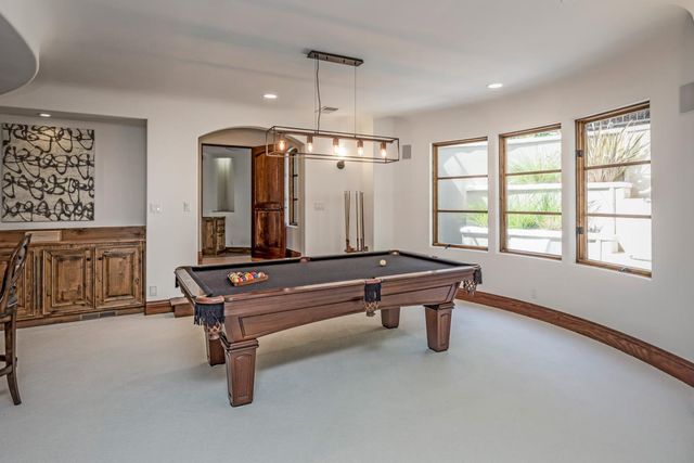 a room with pool table and windows