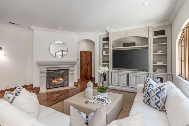 a living room with furniture a fireplace and a flat screen tv