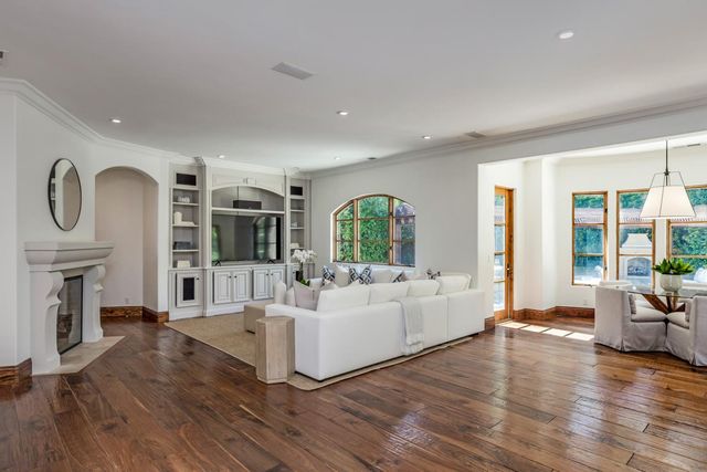 a living room with fireplace furniture wooden floor and a large window