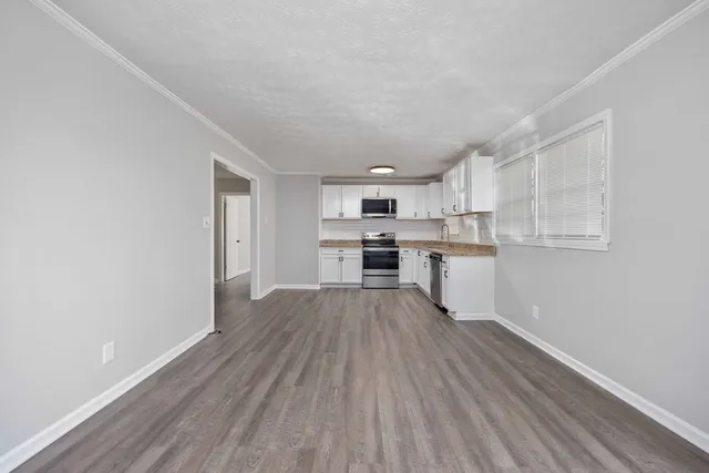 a view of kitchen with wooden floor electronic appliances and window