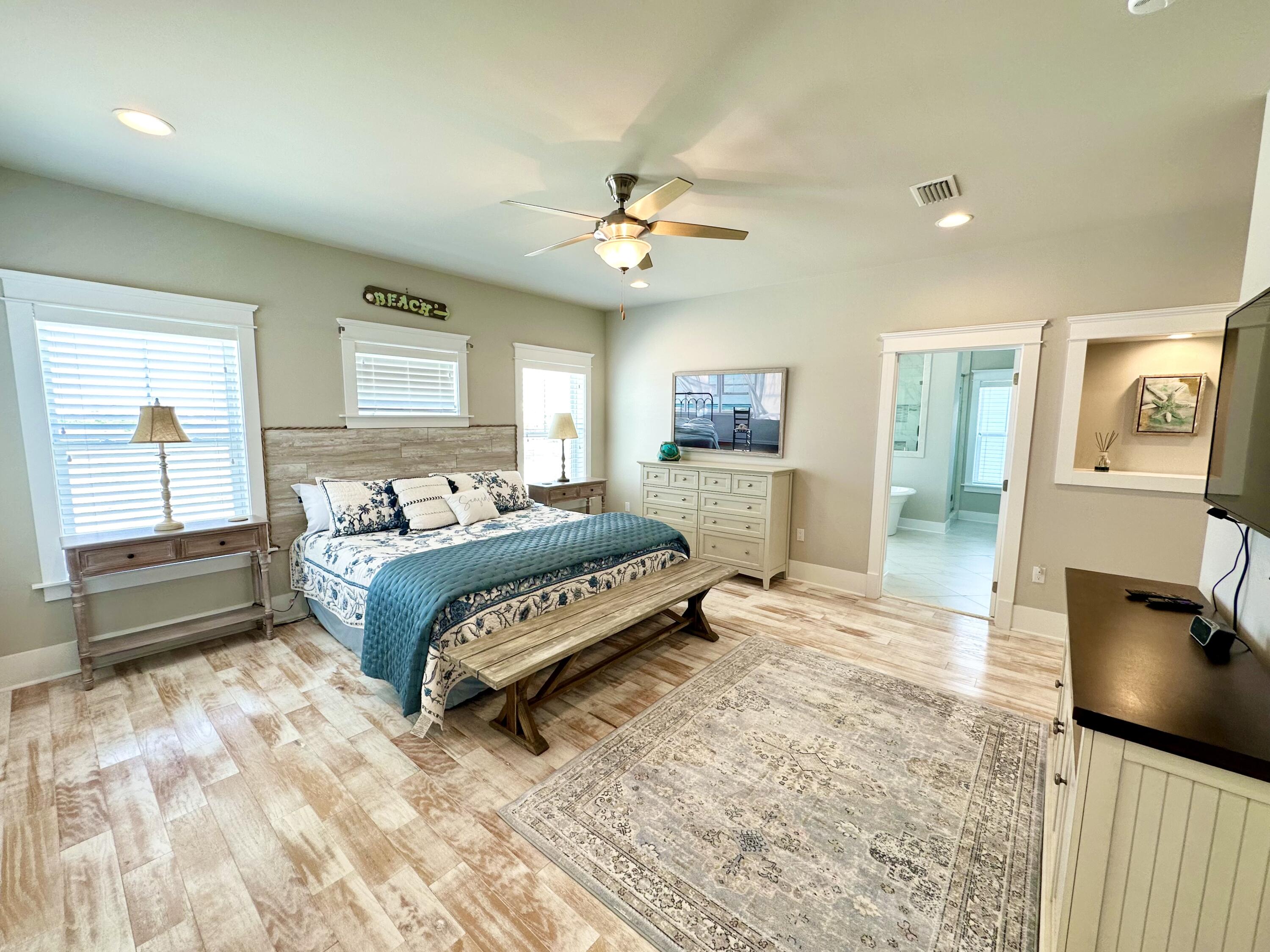 1422 Seaside Circle Navarre, FL 32566 - Photo 21 of 42 a bedroom with a large bed and a chandelier