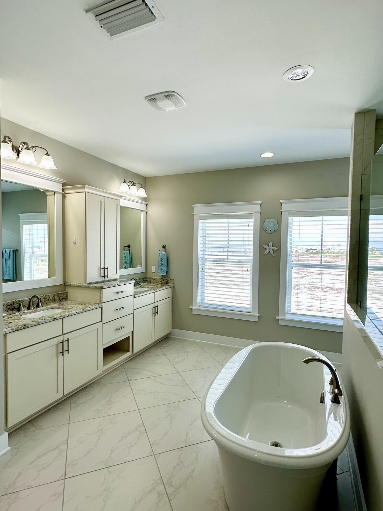 1422 Seaside Circle Navarre, FL 32566 - Photo 22 of 42 a large bathroom with a granite countertop tub sink a mirror and a bathtub