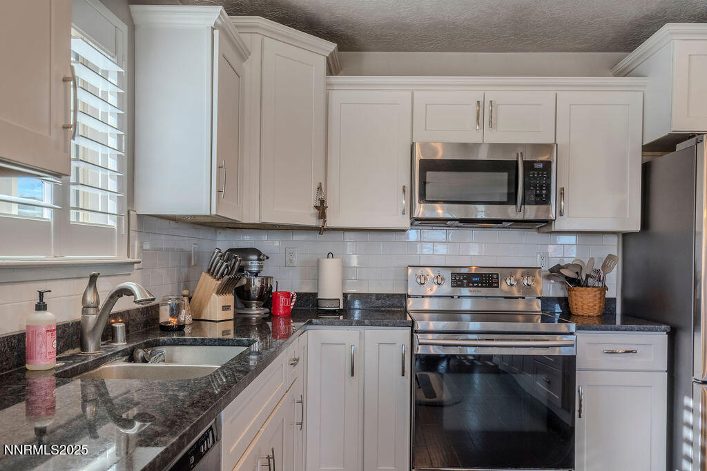 314 Bens Way Fernley, NV 89408 - Photo 15 of 43 a kitchen with stainless steel appliances granite countertop a sink stove microwave and cabinets