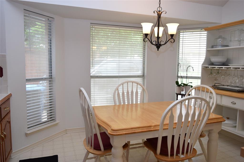 4201 Glistening Spring Rowlett, TX 75088 - Photo 9 of 33 Dining area featuring a bay window with blinds, a multi-light chandelier, and tiled flooring