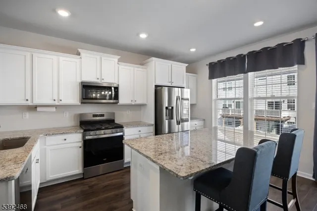 a kitchen with stainless steel appliances granite countertop a sink stove microwave and cabinets