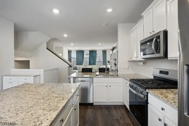 a room with kitchen island a sink dishwasher a dining table and chairs with wooden floor