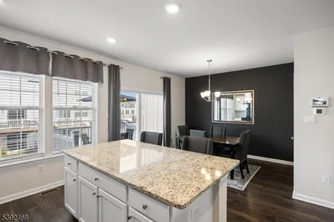 a kitchen with refrigerator a sink and chairs