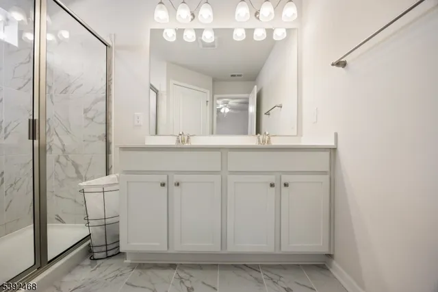 a bathroom with a shower and a sink a mirror