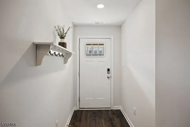 a view of entryway and hall with wooden floor