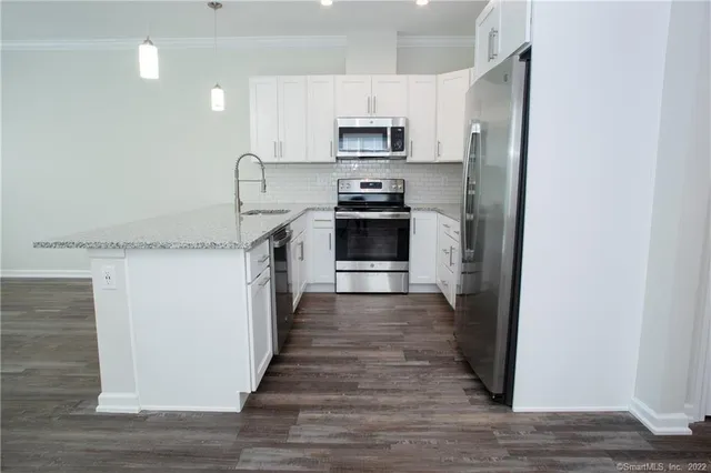 a kitchen with granite countertop a stove top oven and cabinets