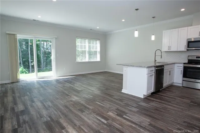 a kitchen with stainless steel appliances granite countertop a stove a sink and a refrigerator