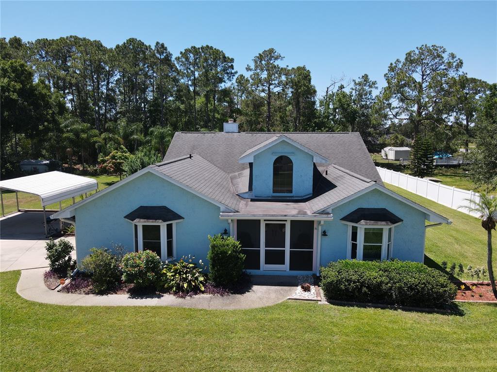 6610 Bay Tree Court St. Cloud, FL 34771 - Photo 1 of 1 a view of a white house with a yard and potted plants