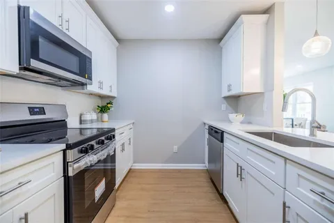 a kitchen with stainless steel appliances a stove microwave and sink
