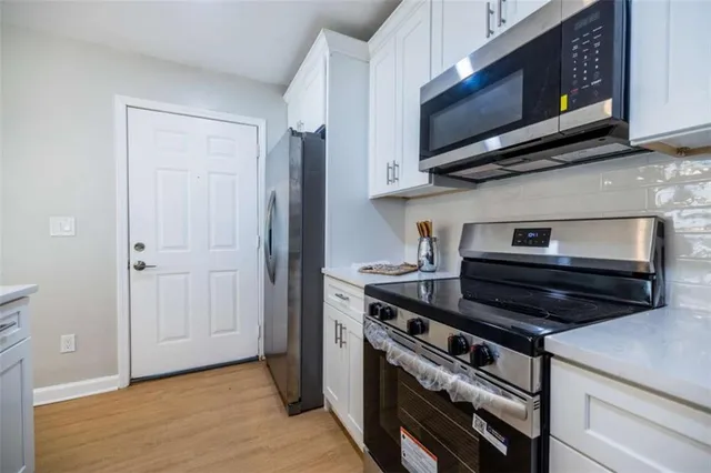 a kitchen with stainless steel appliances a stove a microwave and cabinets
