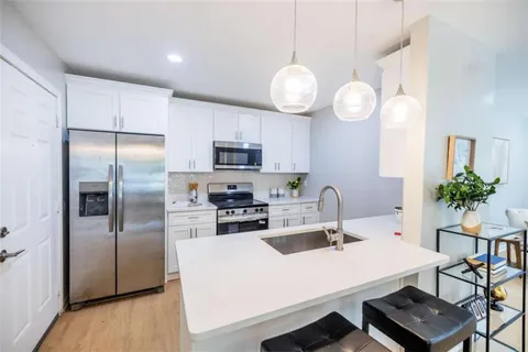 a kitchen with cabinets appliances and a counter space